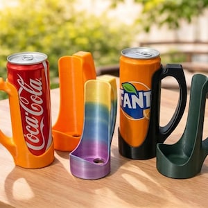 May include: A collection of colorful can holders and sleeves. The holders are orange, black, and green, designed to fit around soda cans. One holder is a gradient of purple, blue, and yellow. A Coca-Cola and Fanta can are in the holders.