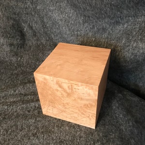 Könnte beinhalten: Eine quadratische Holzkiste mit einer hellbraunen Oberfläche und einem natürlichen Holzmaserungsmuster. Die Kiste ist aus Ahornholz gefertigt und hat eine glatte, polierte Oberfläche.