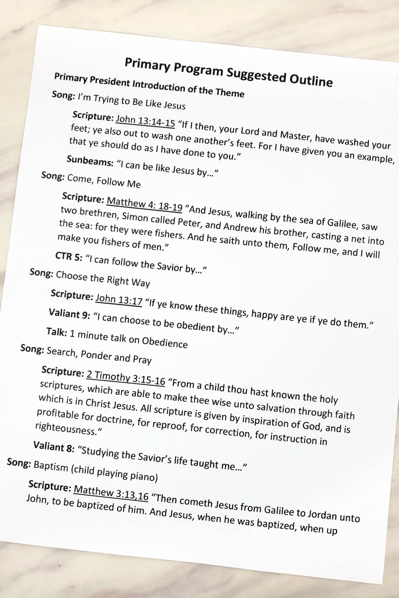 May include: A white sheet of paper with black printed text titled Primary Program Suggested Outline. The document lists various songs, scripture references including John 13:14-15 and Matthew 4:18-19, and prompts for children such as I can be like Jesus by.