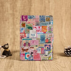May include: A rectangular case covered in a collage of colorful vintage postage stamps. The stamps feature various designs, including flowers, animals, and text. The case is set against a wooden background.