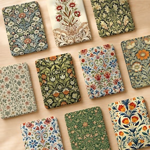 May include: A collection of ten rectangular e-reader cases featuring diverse floral and botanical patterns. The designs include intricate arrangements of flowers, leaves, and vines in various color palettes such as cream, green, orange, and blue.