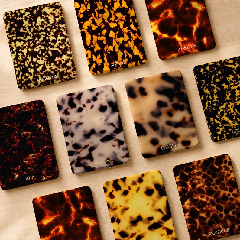 May include: A collection of ten rectangular cases featuring various tortoiseshell patterns in shades of amber, black, brown, and cream. Each case is personalized with a name printed in white, including Dorothy, Sophie, Adeline, Ada, Eleanora, Camilla, and Beatrice.