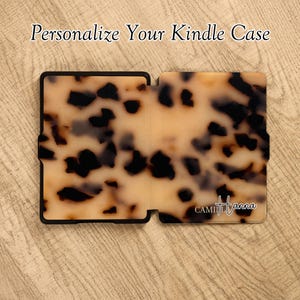 May include: A rectangular Kindle case featuring a brown and black tortoiseshell pattern. The text "Personalize Your Kindle Case" appears at the top, and the name "CAMILLA Hanna" is printed in white script in the bottom right corner of the case.