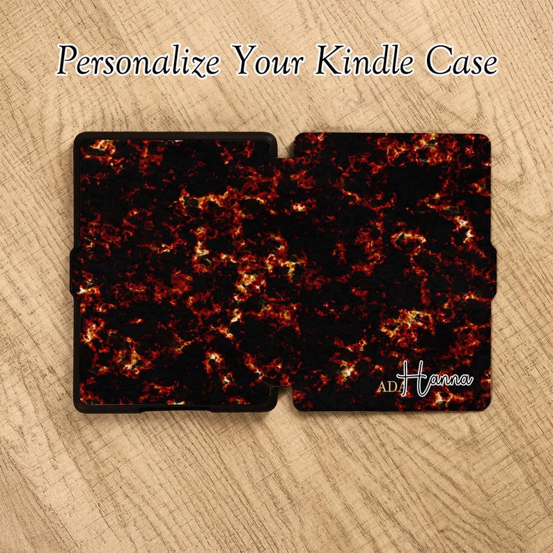 May include: A Kindle case featuring a black and fiery orange marbled pattern. The text "Personalize Your Kindle Case" appears at the top, and the name "ADA Hanna" is printed in white script on the bottom right corner of the cover.