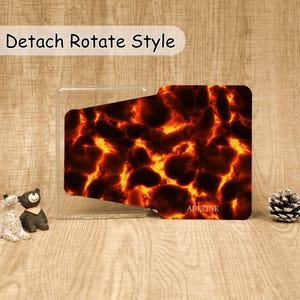 May include: A rectangular phone grip with a fiery lava pattern featuring glowing orange and yellow veins against dark brown and black shapes. The text "Detach Rotate Style" appears at the top, and the name "ADELINE" is printed in white at the bottom.