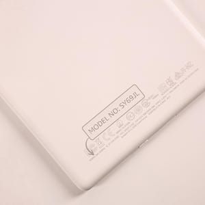 May include: A white electronic device back panel featuring the text MODEL NO: SY69JL enclosed in a rectangular border. Below this, various regulatory symbols, certification marks, and technical specifications are printed in light gray ink.