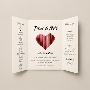 Könnte beinhalten: Eine dreifach gefaltete Hochzeitseinladungskarte mit einem zentralen, roten gestickten Herz. Der Text lautet Titus & Nele, Wir heiraten, und enthält einen Zeitplan von 13 Uhr bis 20 Uhr sowie RSVP- und Geschenk-Informationen auf den Seiten.