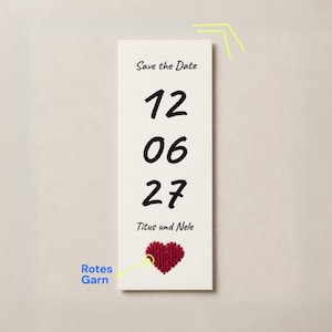 Könnte beinhalten: Eine rechteckige cremefarbene Karte mit dem Text Save the Date, den Zahlen 12 06 27 und den Namen Titus und Nele. Unter den Namen befindet sich ein kleines, strukturiertes rotes Herz aus Garn. Ein gelber Pfeil zeigt mit dem Text Rotes Garn darauf.