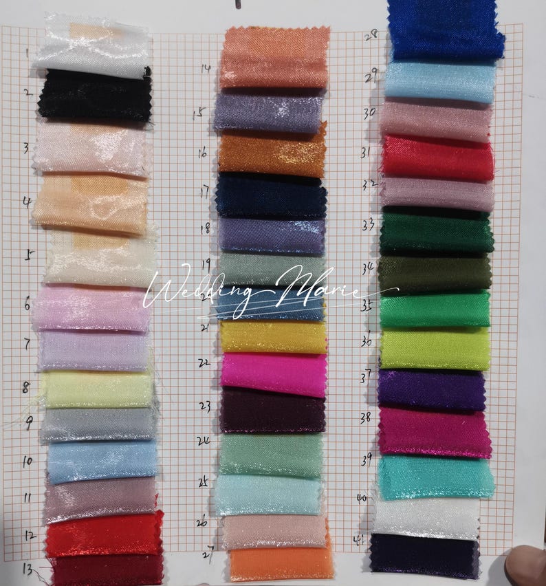 Puede incluir: Una carta de colores con muestras de tela en una variedad de colores, incluyendo rosa, azul, verde y morado. Las muestras est&aacute;n dispuestas en columnas verticales, con cada muestra midiendo aproximadamente 2,5 cm por 2,5 cm. El fondo es una cuadr&iacute;cula.