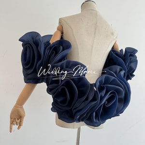 May include: Navy blue, floral-shaped shoulder wrap. The wrap is made of a sheer fabric and is draped over a mannequin. The text "Wedding Marie" is written in cursive on the wrap.