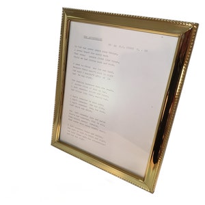 May include: A gold-framed picture with a white background and a typed poem titled "The Alternatives" by A.M.C. STATHAM. The poem reads: "If that was over short, some think, I never heard his very worth. That other people lived like this, while we had little much and more. I used to think that lot was hard, but had those short, such as they, had they been much better, oh so right, and was I right. Our earliest background came to pass, I seldom think of those we met, I just remember that and there, and those like this, mostly had. I don't remember three meals each, I don't remember on a county fair, I don't remember who for whom, I just remember which for mine. Some had nothing but and some, there's something just and fair, some had always that, that is all. I just remember money, money, money, I just remember that and there. I feel that there is right and wrong, but could be heaven after all, but just not right, the alternatives."