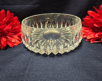 May include: A clear glass bowl with a diamond-shaped pattern. The bowl is empty and sitting on a dark blue surface.