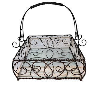 May include: A black metal serving tray with a glass bottom and a decorative scroll design. The tray has a handle for easy carrying.