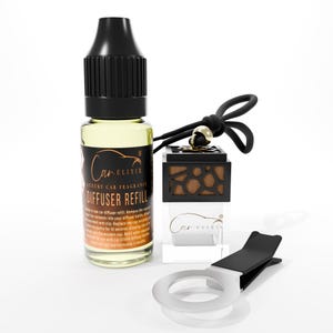May include: A car air freshener set with a bottle of yellow liquid, a black and wood-grain diffuser, and a silver clip. The bottle has a black cap and a label that reads "Car Elixir Luxury Car Fragrance Diffuser Refill."