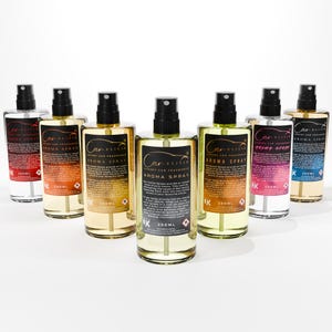 May include: A collection of car air freshener aroma spray bottles. Each bottle has a black spray nozzle and a label with the text "Car Elixir Luxury Car Fragrance Aroma Spray". The bottles contain a clear liquid and are labeled 250ml.