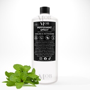 Może przedstawiać: Przezroczysta plastikowa butelka z czarną zakrętką i białą etykietą. Etykieta zawiera napis "MOB Cosmetics Peppermint Spray Mentha piperita Cooling & Refreshing". Butelka stoi na białym tle, na pierwszym planie znajduje się gałązka zielonych liści mięty.