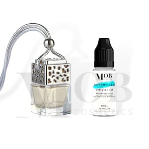 Puede incluir: Un ambientador de coche plateado con una botella de vidrio transparente y una jaula de metal plateado. La botella está llena de un líquido transparente. El ambientador está colgado de una cuerda plateada. Una pequeña botella de aceite difusor con una tapa negra y una etiqueta blanca que dice "MOB COSMETICS SEYCHELLES Diffuser oil Suitable for use in car, electric, reed, air and plugin diffusers. 10mL BN:XXXXXXX www.MOSCOSMETICS.CO.UK" está al lado del ambientador.