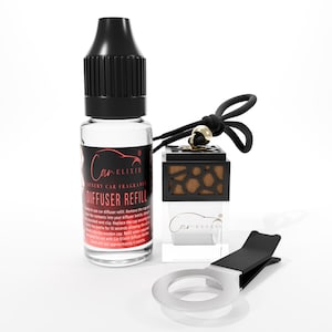 May include: A clear glass bottle of car fragrance diffuser refill with a black cap, a black and gold car air freshener, and a silver vent clip. The bottle has a red and black label with the text "Car Elixir Luxury Car Fragrance Diffuser Refill."