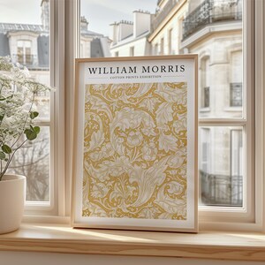 May include: A framed print of a yellow and white floral pattern with the text "WILLIAM MORRIS COTTON PRINTS EXHIBITION" at the top.