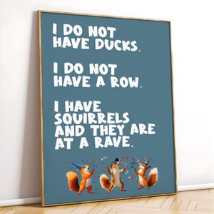 May include: A framed poster with a teal background and gold trim. The text reads "I DO NOT HAVE DUCKS. I DO NOT HAVE A ROW. I HAVE SQUIRRELS AND THEY ARE AT A RAVE." Three cartoon squirrels in party hats are at the bottom.