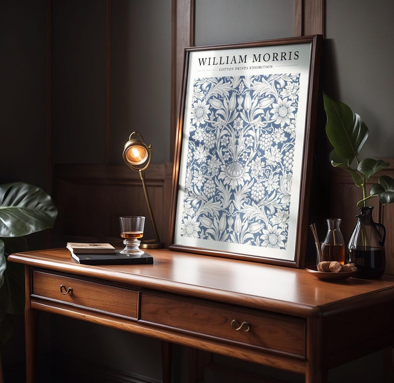 Puede incluir: Una impresi&oacute;n enmarcada de un patr&oacute;n floral azul y blanco con el texto "WILLIAM MORRIS COTTON PRINTS EXHIBITION" en la parte superior.