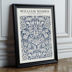 Puede incluir: Una impresi&oacute;n enmarcada de un patr&oacute;n floral azul y blanco con el texto "William Morris - Cotton Prints Exhibition".