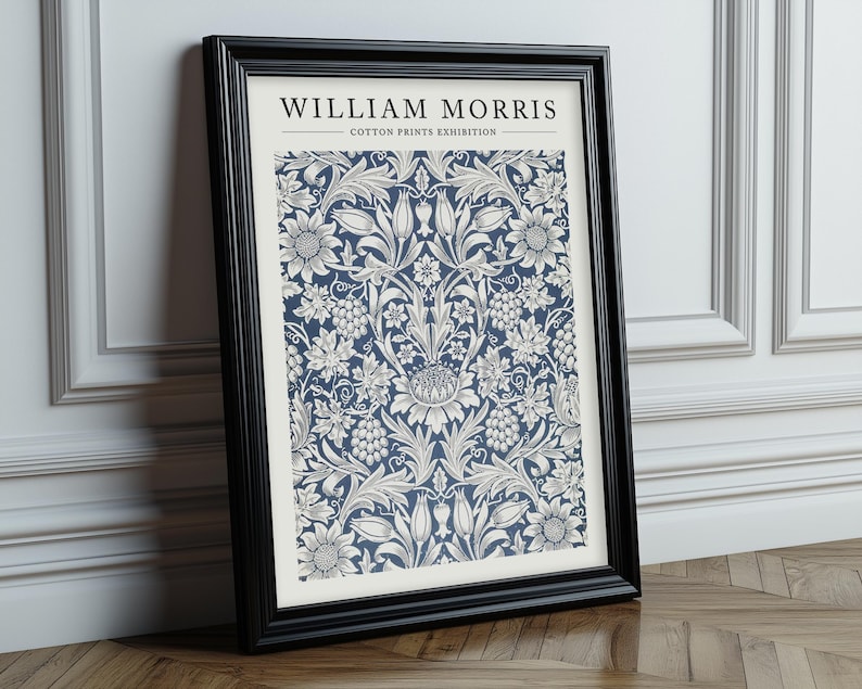Puede incluir: Una impresi&oacute;n enmarcada de un patr&oacute;n floral azul y blanco con el texto "William Morris - Cotton Prints Exhibition".