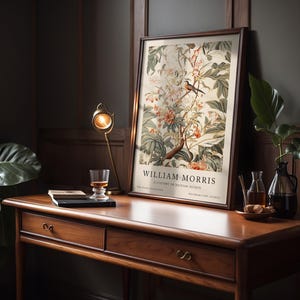 May include: A framed print of a botanical illustration featuring a bird perched on a branch with flowers and leaves. The print is titled "William Morris, A History of British Design".