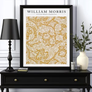 May include: A black framed print with the text "WILLIAM MORRIS - COTTON PRINTS EXHIBITION" and a yellow and white floral pattern.