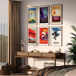 May include: Six framed posters with colorful illustrations of planets and space exploration. The posters are hung on a white wall in a modern living room setting. The posters feature the text "Kepler-186f", "Jupiter", "Mars", "Moon", "HD 40307g", and "Kepler-10b".