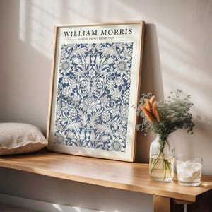 Puede incluir: Una impresi&oacute;n enmarcada de un patr&oacute;n floral azul y blanco con el texto "WILLIAM MORRIS COTTON PRINTS EXHIBITION".