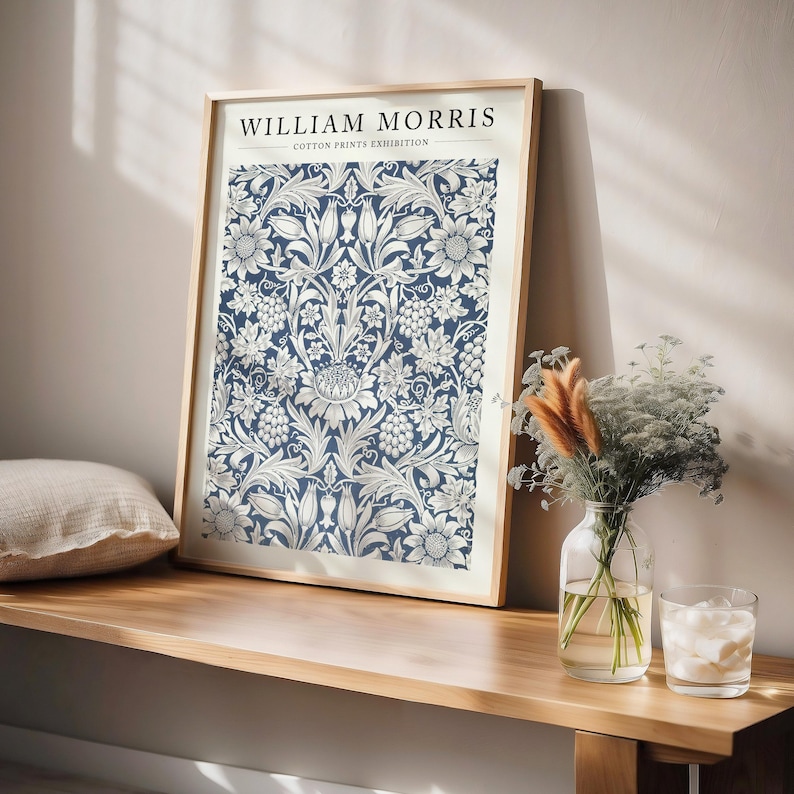 Puede incluir: Una impresi&oacute;n enmarcada de un patr&oacute;n floral azul y blanco con el texto "WILLIAM MORRIS COTTON PRINTS EXHIBITION".