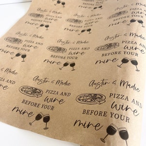 May include: Brown paper wrapping paper with a repeating pattern of a pizza slice and wine glasses with the text "Austin & Madie Pizza and Wine Before Your Mine" printed on it.
