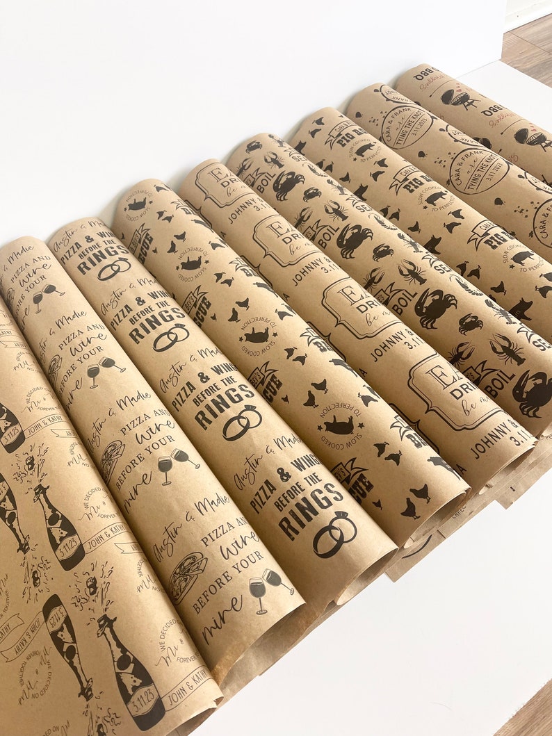 May include: A stack of brown paper gift wrap rolls with a repeating pattern of a pizza slice, wine glass, and the text "Pizza & Wine Before the Rings".
