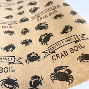 May include: Brown paper wrapping paper with a repeating pattern of black crabs and the text "Smith Family Crab Boil".