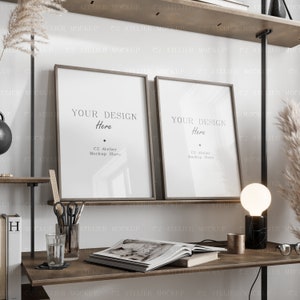 May include: Two framed mockups with the text "Your Design Here" and the company name "C2 Atelier Mockup Store" on a wooden shelf with a table lamp and a book on the table below.
