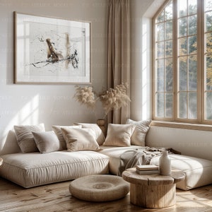 Peut inclure: Un canap&eacute; d'angle beige avec une table basse en bois et un vase avec des fleurs s&eacute;ch&eacute;es. Un tableau abstrait encadr&eacute; est accroch&eacute; au mur derri&egrave;re le canap&eacute;. La pi&egrave;ce a une grande fen&ecirc;tre avec vue sur les arbres &agrave; l'ext&eacute;rieur.