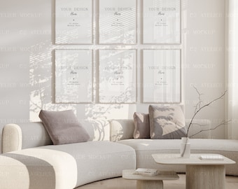 May include: Six white picture frames with silver trim are hanging on a white wall. The frames are arranged in two rows of three. The frames are empty and ready for your design. The frames are hanging in a living room with a white couch and a wooden coffee table.