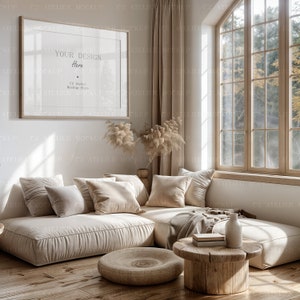 Peut inclure: Un canap&eacute; d'angle beige avec des coussins et une couverture se trouve dans un salon avec une grande fen&ecirc;tre. Une table basse en bois avec un vase et des livres se trouve devant le canap&eacute;. Un pouf rond en osier se trouve sur le sol en bois. Le mur est blanc avec un cadre photo qui dit "Your Design Here".