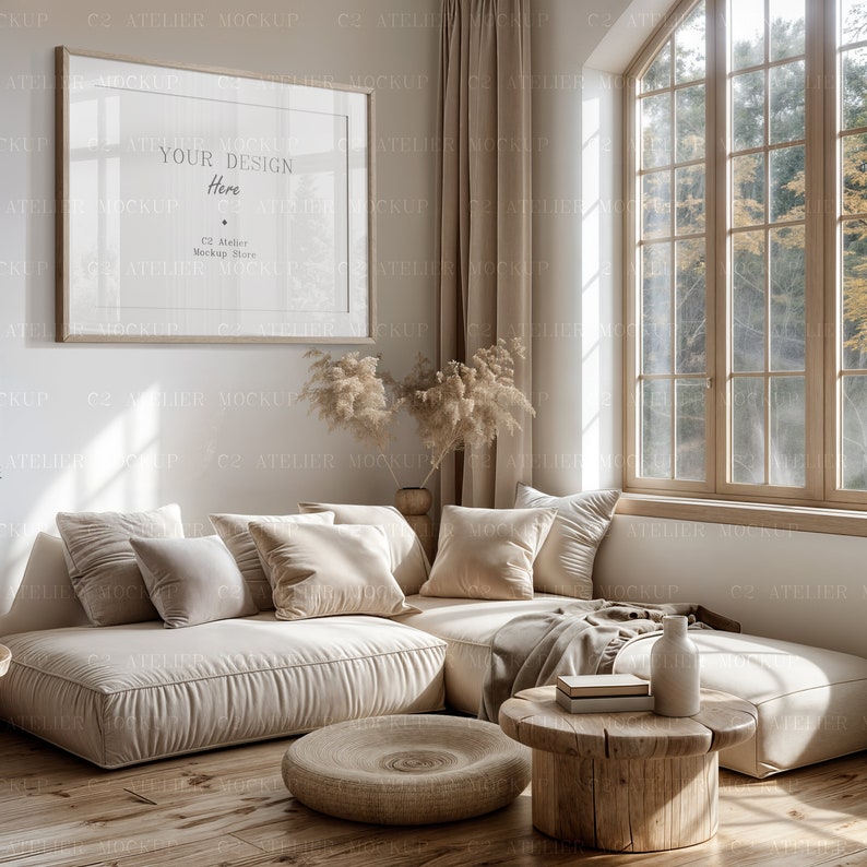 Peut inclure: Un canap&eacute; d'angle beige avec des coussins et une couverture se trouve dans un salon avec une grande fen&ecirc;tre. Une table basse en bois avec un vase et des livres se trouve devant le canap&eacute;. Un pouf rond en osier se trouve sur le sol en bois. Le mur est blanc avec un cadre photo qui dit "Your Design Here".