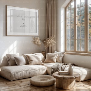 Peut inclure: Un canap&eacute; d'angle beige avec plusieurs coussins est plac&eacute; dans un salon avec une grande fen&ecirc;tre. Le canap&eacute; est devant un mur blanc avec un tableau encadr&eacute; au-dessus. Le tableau a un fond transparent et le texte "Your Design Here" et "C2 Atelier Mockup Store". Le sol est en planches de bois.