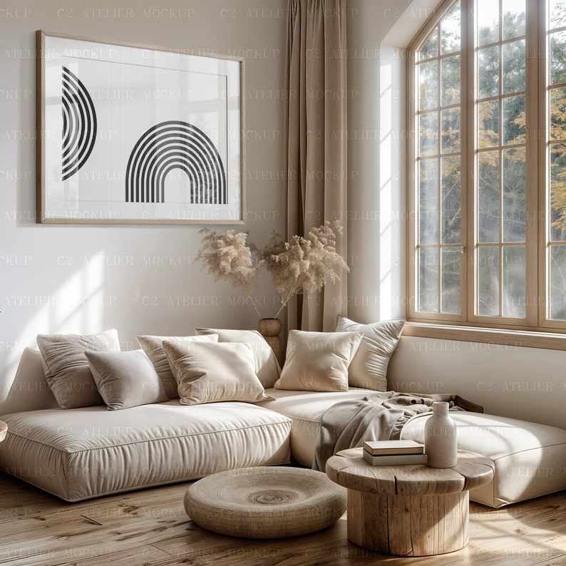 Peut inclure: Un canap&eacute; d'angle beige avec des coussins et une couverture se trouve dans un salon avec une grande fen&ecirc;tre. Une table basse en bois avec un vase et des livres se trouve devant le canap&eacute;. Une estampe encadr&eacute;e avec des formes g&eacute;om&eacute;triques noires est accroch&eacute;e au mur.