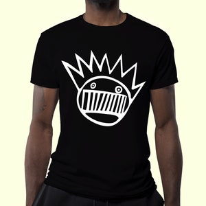 Puede incluir: Camiseta negra con un gráfico blanco de una cara de dibujos animados con una corona de púas y una boca con líneas horizontales.