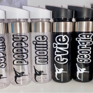 Pode incluir: Seis garrafas de água personalizadas com tampas prateadas e letras pretas. Os nomes nas garrafas são Sophie, Poppy, Mollie, Evie, Georgia e Lauren.