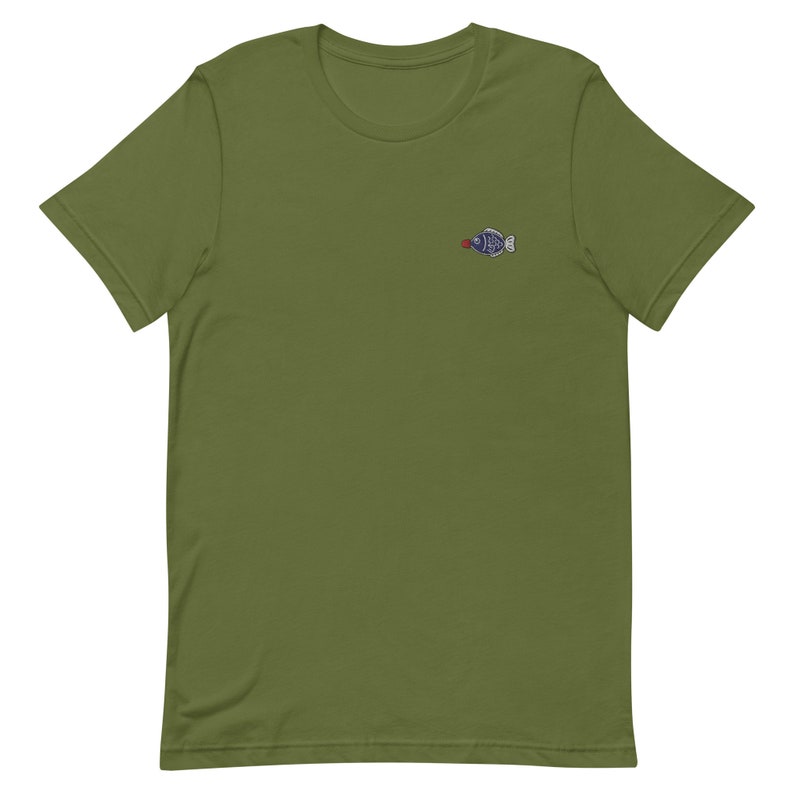 May include: A green short-sleeved t-shirt with a small embroidered fish design on the left chest.