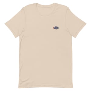 May include: A beige short-sleeved t-shirt with a small embroidered blue fish design on the front.
