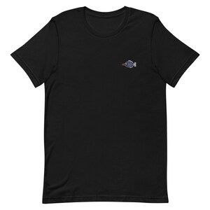 May include: Black t-shirt with a small embroidered fish design in blue and red.