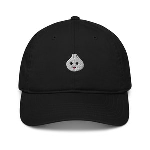 May include: A black baseball cap with an embroidered white and gray cartoon dumpling with a pink tongue.