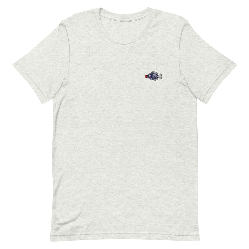 May include: A heather grey t-shirt with a small embroidered fish design in blue and red.