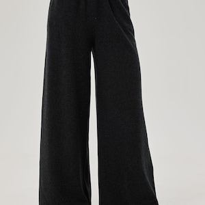 May include: Wide-leg pants in a dark charcoal gray color. The pants have a relaxed fit and a comfortable elastic waistband.